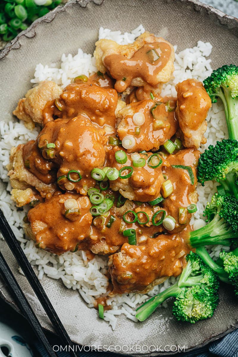 Homemade peanut butter chicken with broccoli over steamed rice close up