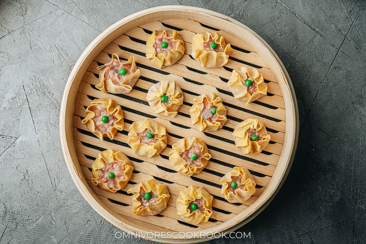 Uncooked shumai in a bamboo steamer