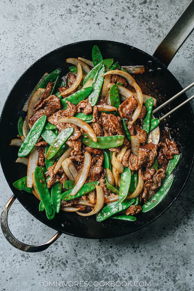 Beef with snow peas in a frying pan