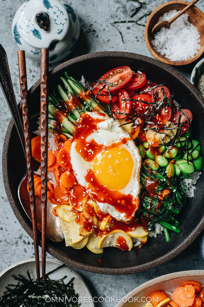 Summer vegetable bibimbap with sunny side egg and chili sauce close up