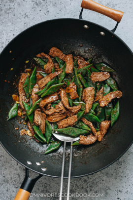 Steak and green beans stir fry in a wok