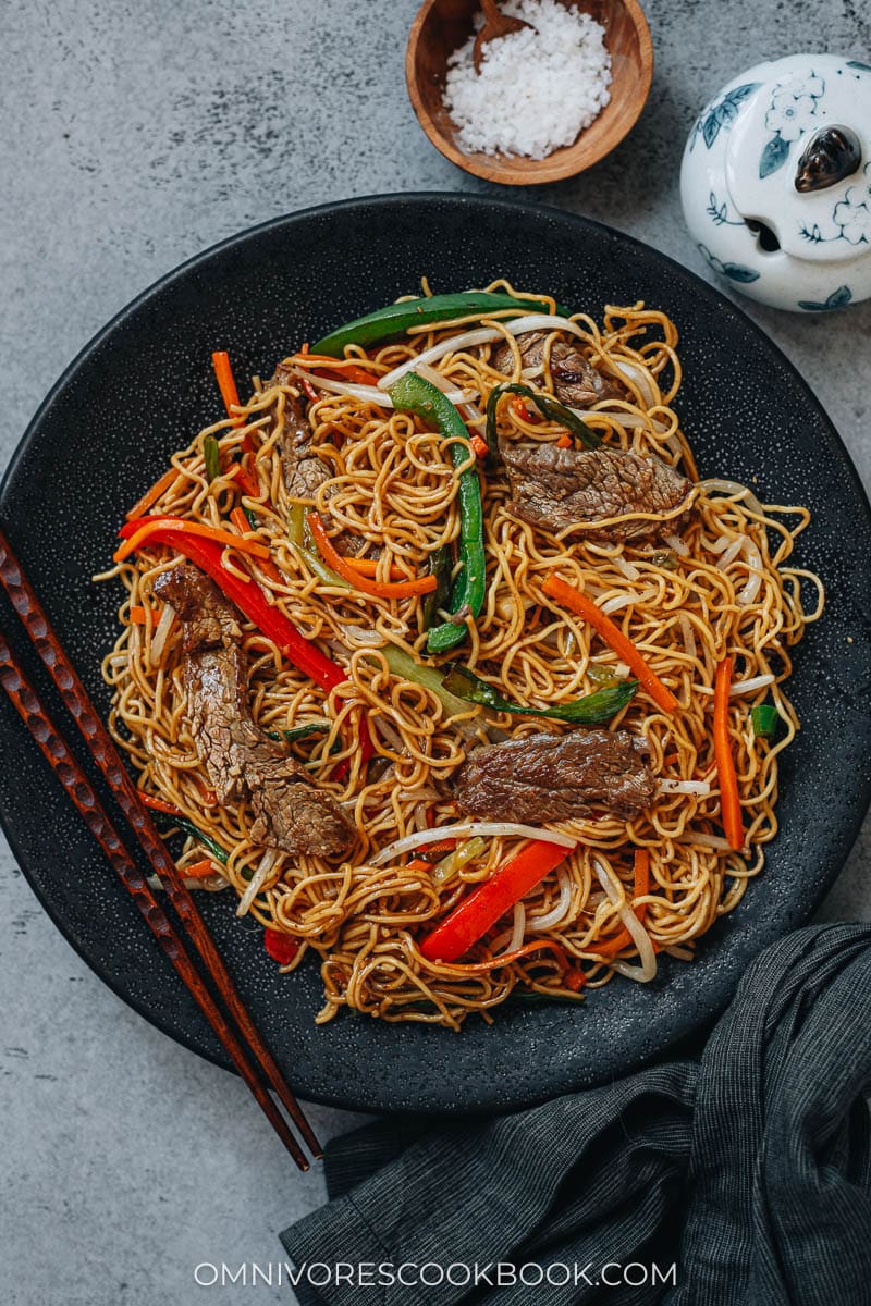Homemade beef chow mein in skillet and served in plates