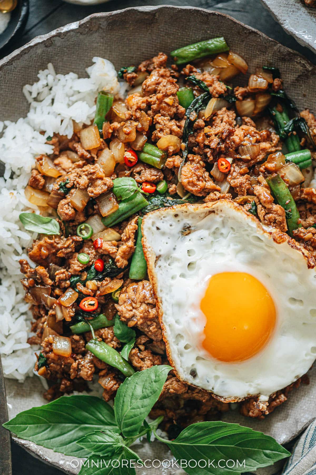 Thai basil chicken over rice with sunny eggs close up