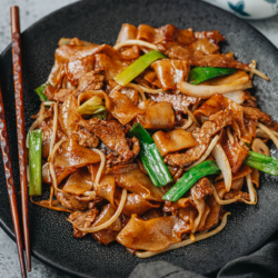 Homemade beef chow fun features thick, chewy noodles, tender juicy steak, and crisp veggies brought together with a fragrant brown sauce. Cook these restaurant-style fried noodles in your home kitchen with ease using my recipe! {Gluten-Free Adaptable}