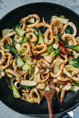 Squid and bok choy stir fry in a pan close up