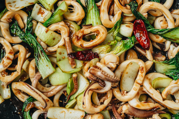 Squid and bok choy stir fry in a pan close up