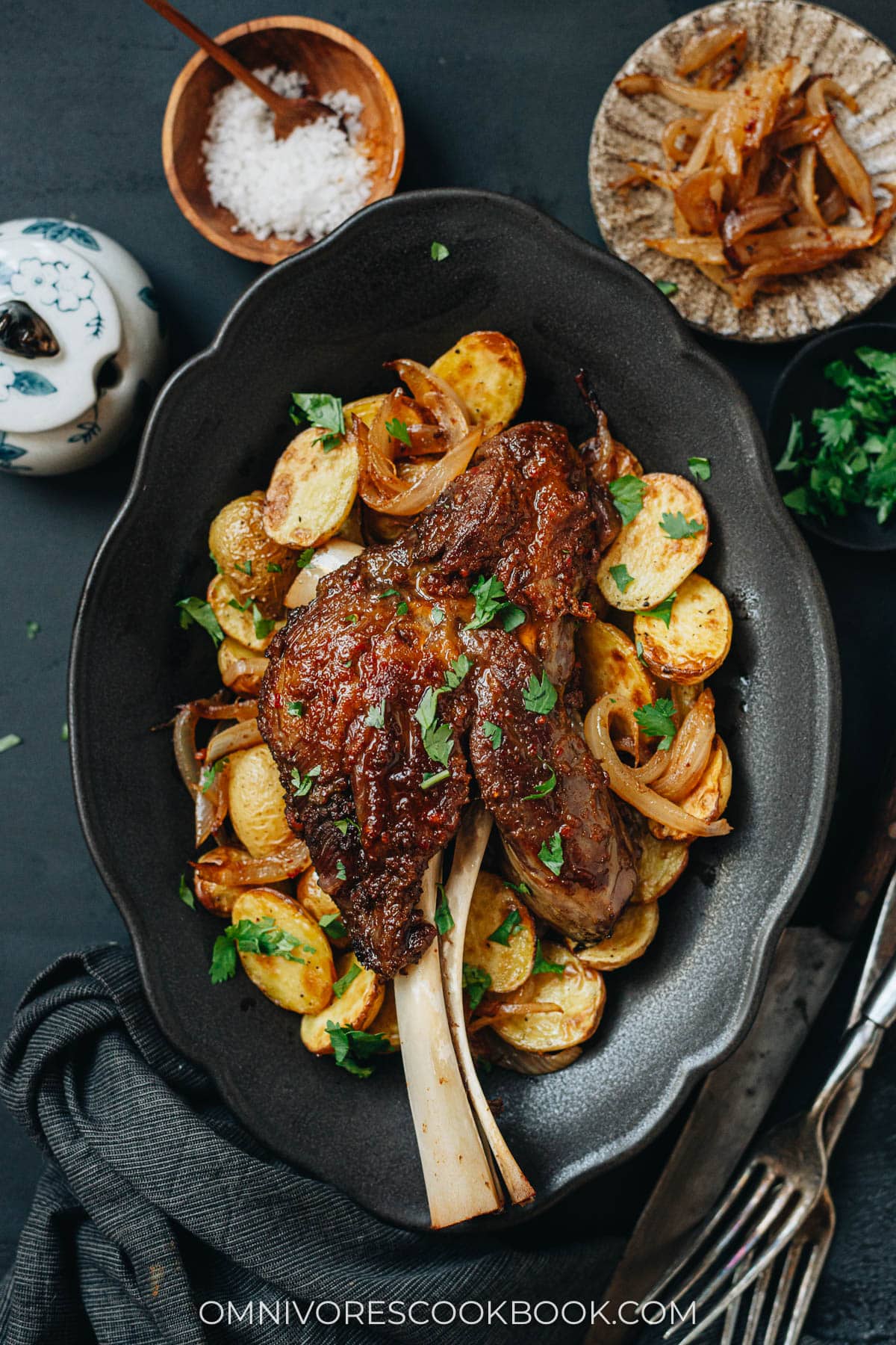 Roast lamb shank over a bed of roast potato and onion