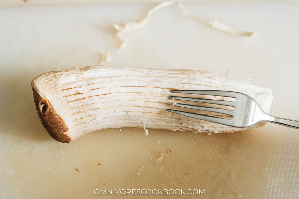 Use a fork to scrape king oyster mushroom