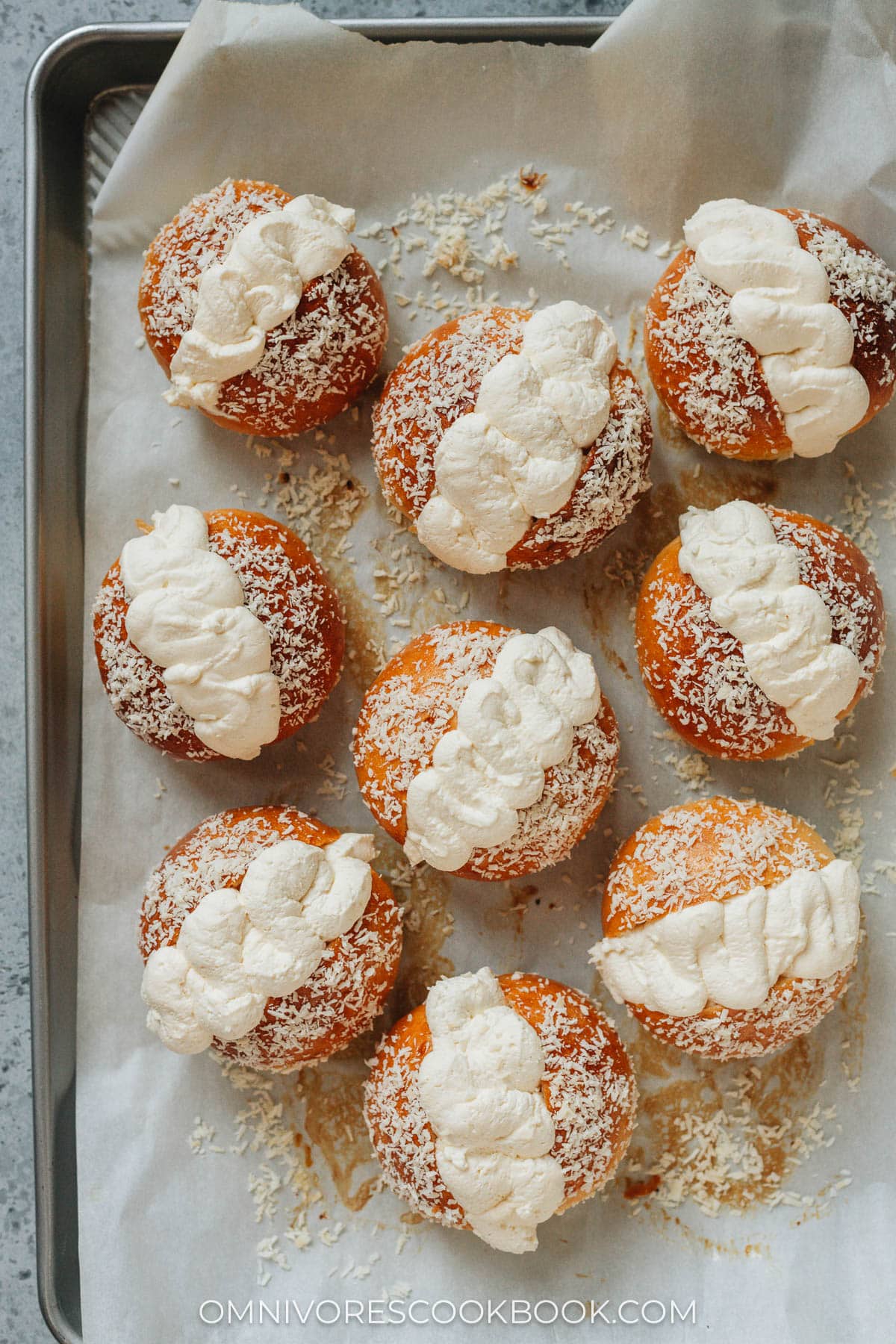 Coconut cream buns on a baking tray