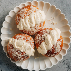 These Chinese bakery style coconut cream buns feature a pillowy and soft milk bread dough decorated with shredded coconut and filled with whipped cream.