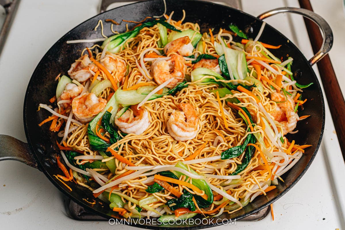 Cook shrimp chow mein on a stove