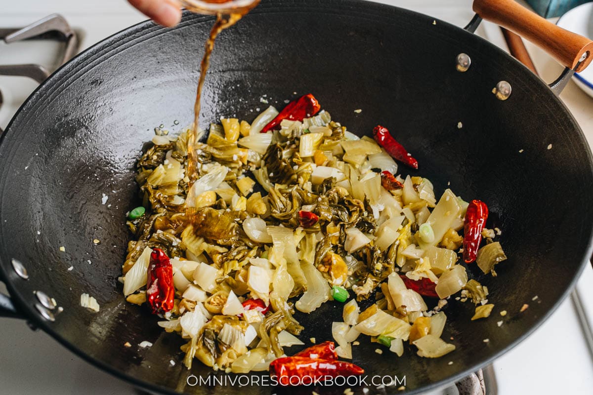 Adding mustard greens and Shaoxing wine