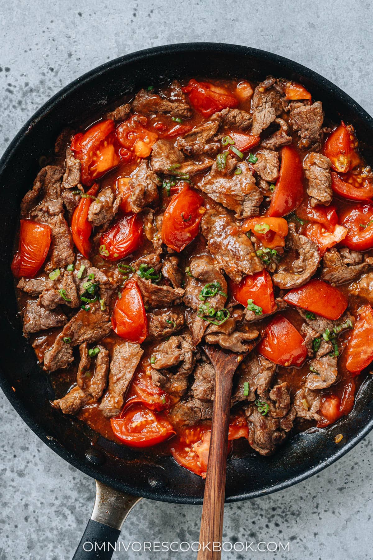 Chinese beef and tomato stir fry in a pan