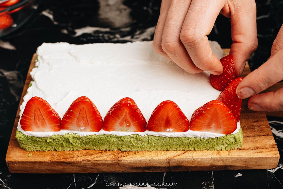 Decorating matcha cake with strawberries