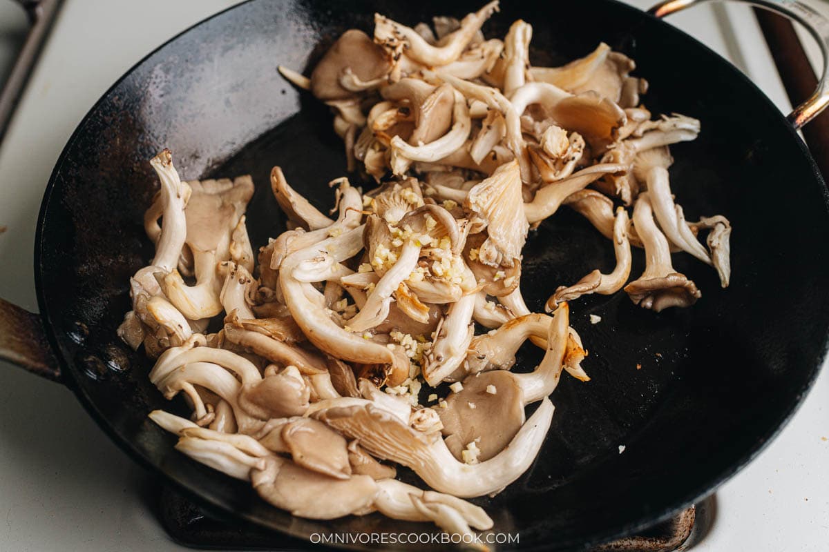 Pan frying oyster mushroom and adding garlic