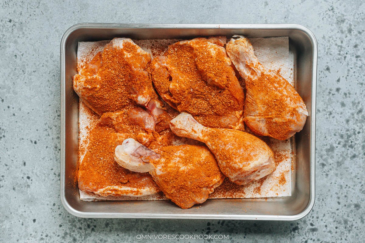 Rubbing spice mix over chicken pieces