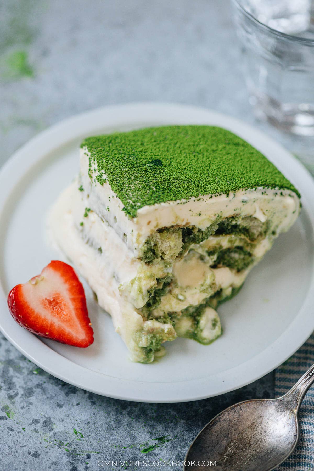Sliced matcha tiramisu on a plate with strawberry