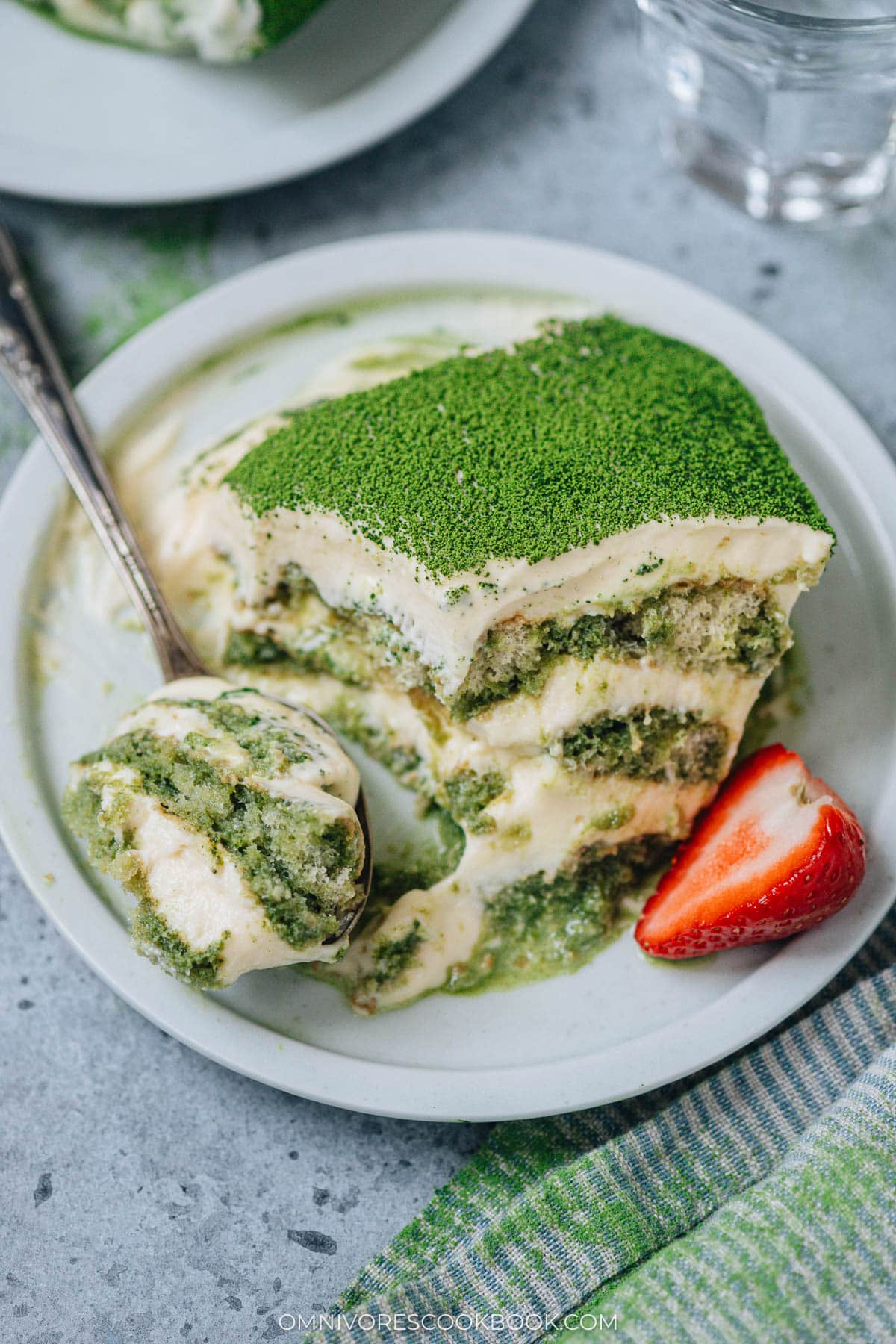 Taking a bite from a piece of matcha tiramisu