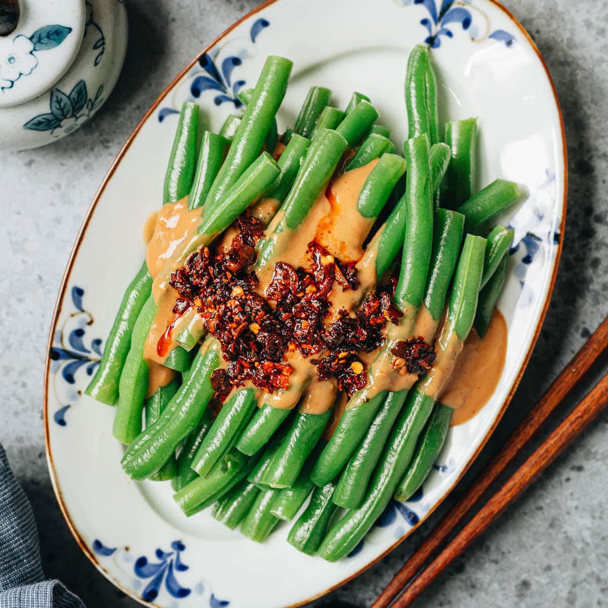 Green beans with spicy peanut sauce is an easy appetizer or side dish that will fit nicely into any of your meals. Crisp green beans are tossed with a nutty sauce that is slightly sweet and tangy, enhanced by chili crisp for a satisfying taste. And it only takes 6 ingredients to make. {Gluten-Free Adaptable, Vegetarian}
