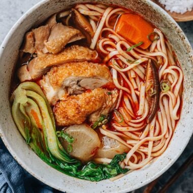 Chinese spicy chicken noodle soup with bok choy served in a bowl