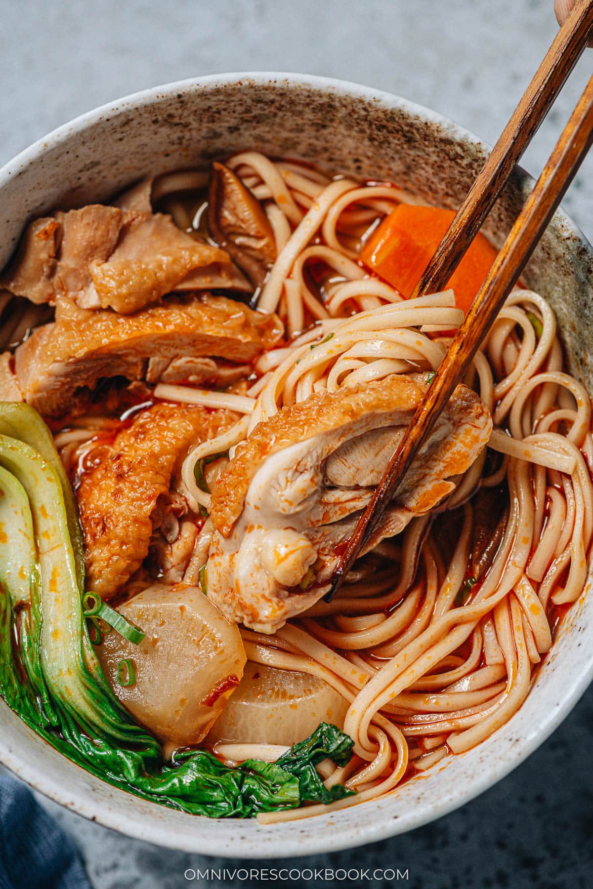 Chinese spicy chicken noodle soup close up with chopsticks