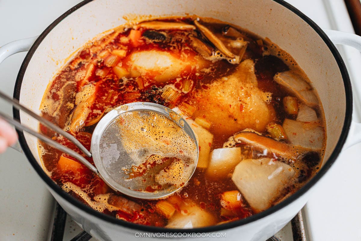 Simmer the chicken soup and skim the soup