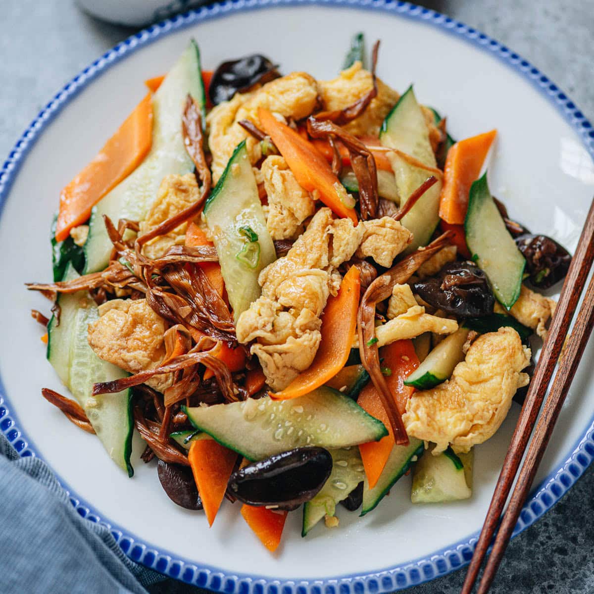 Crisp cucumber and tender eggs are stir fried with simple seasonings and aromatics, elevated by dried lily flowers and wood ear mushrooms for texture. I want to share this family recipe that makes a vegetable dish so satisfying.