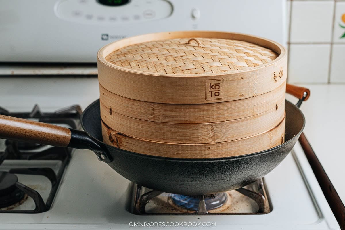 Cooking with bamboo steamer over wok