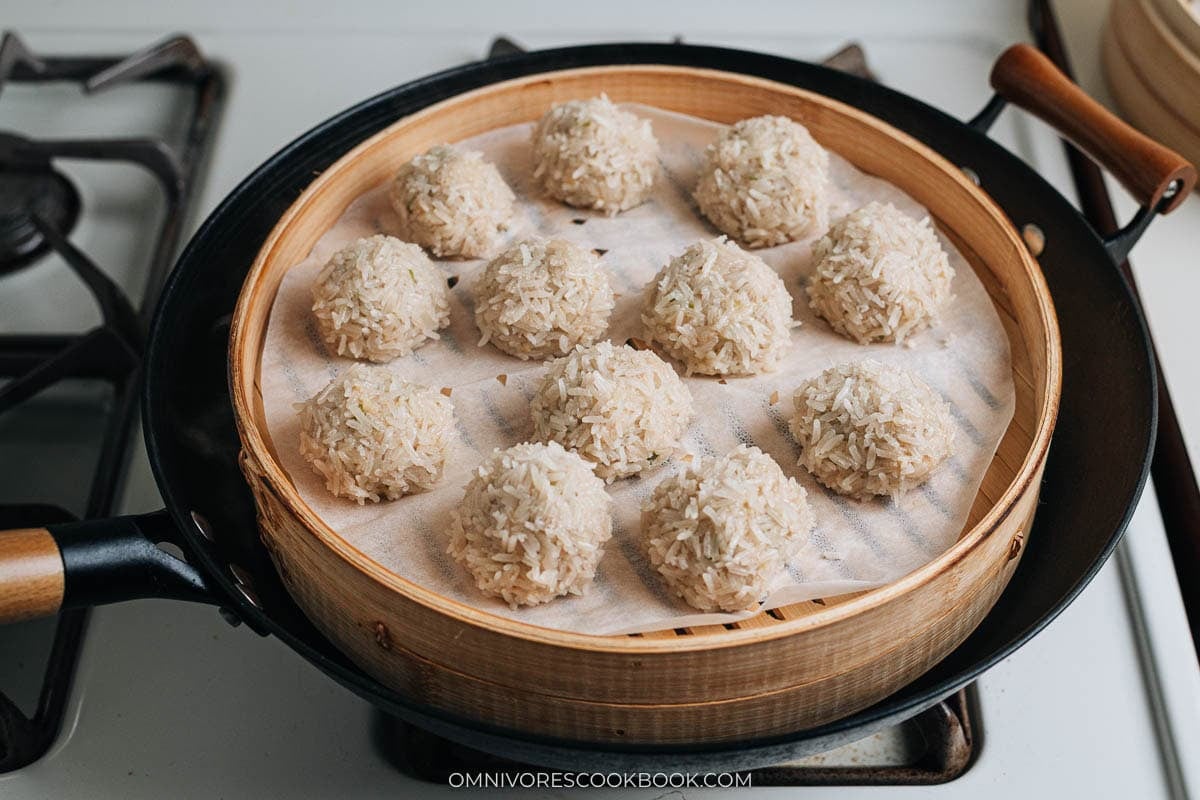 Cooked Chinese pearl balls in the bamboo steamer over a wok