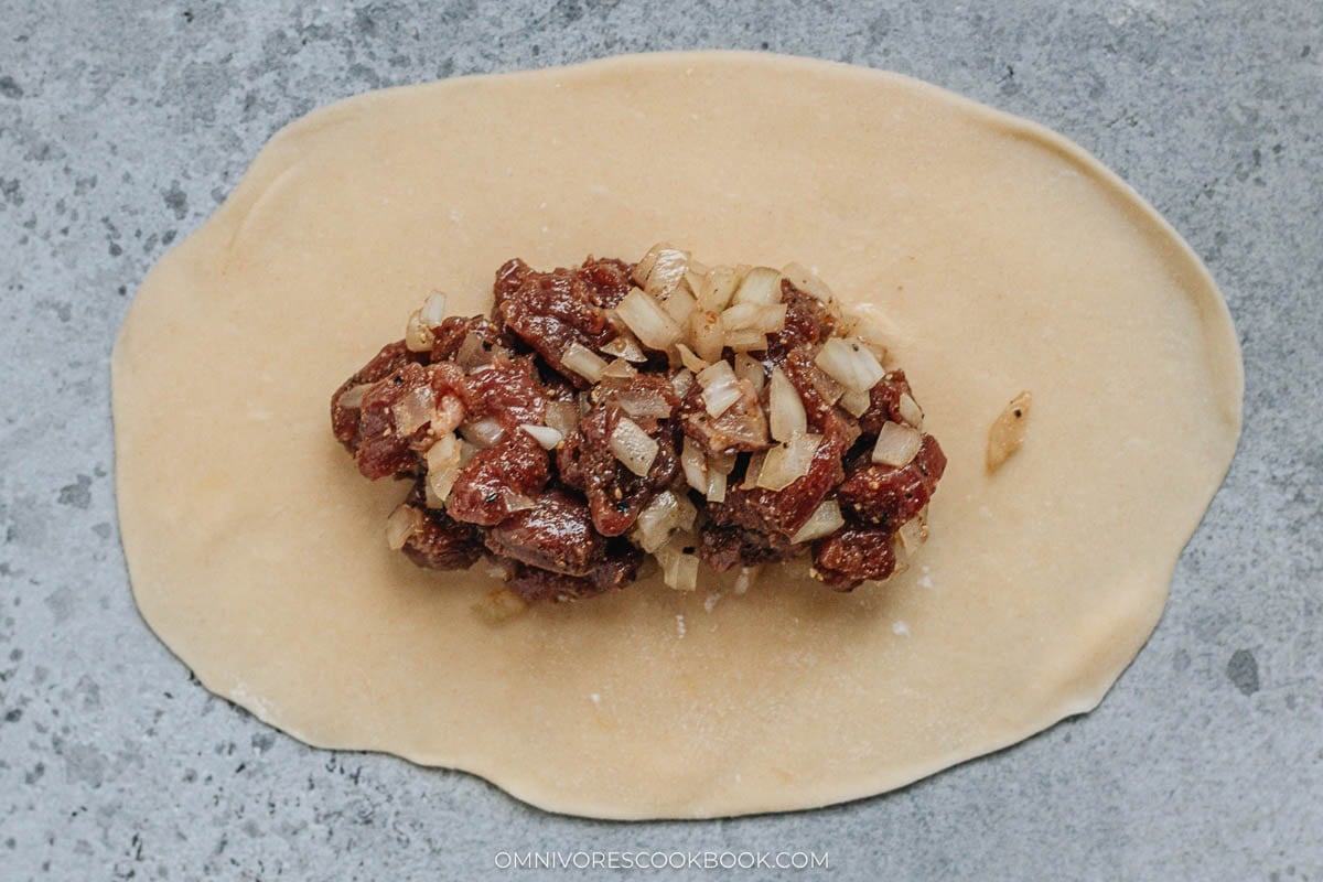 Adding lamb filling onto the wrapper