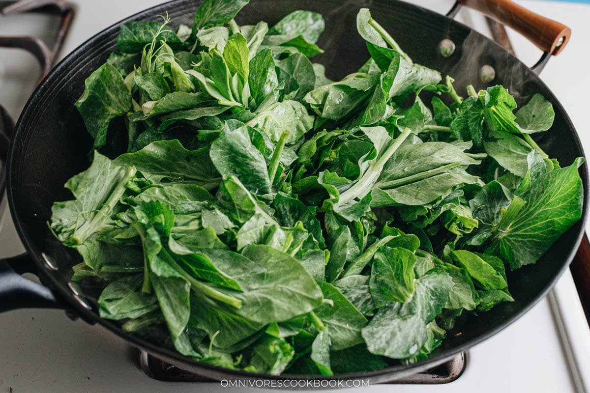 Cooking pea shoots in a wok