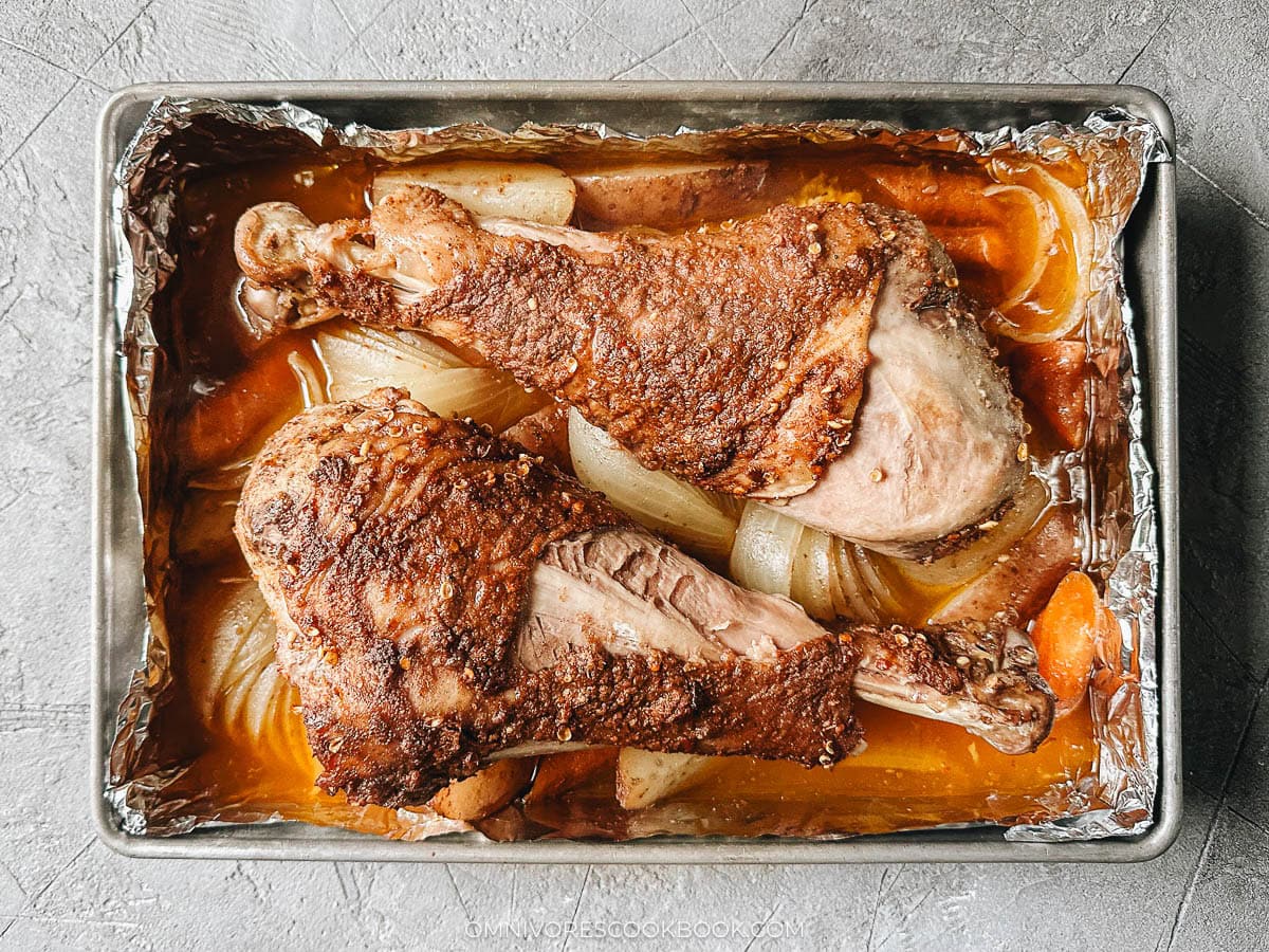 Roast turkey legs over a bed of vegetable