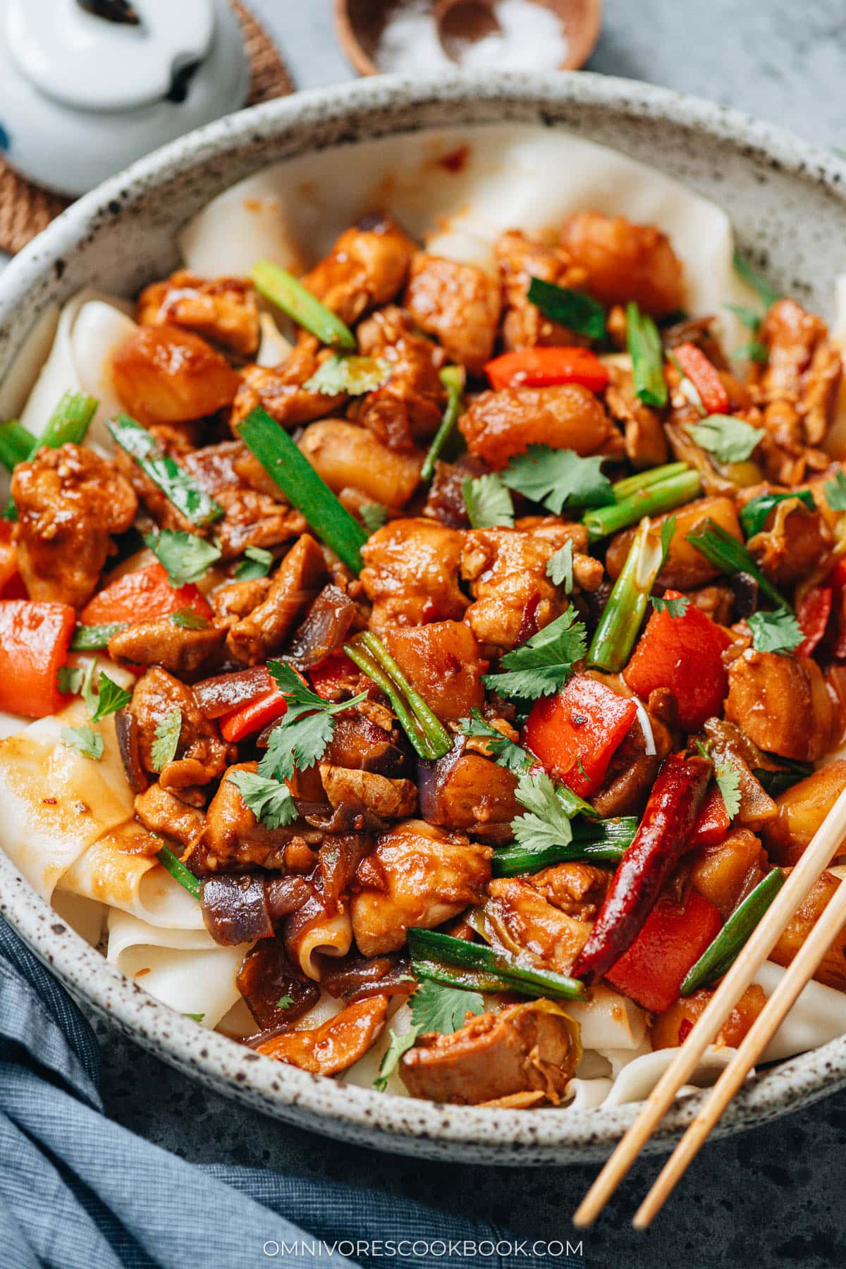 Close-up of Big Plate Chicken showing tender chicken pieces, soft potatoes, red peppers, and scallions coated in rich spicy sauce.
