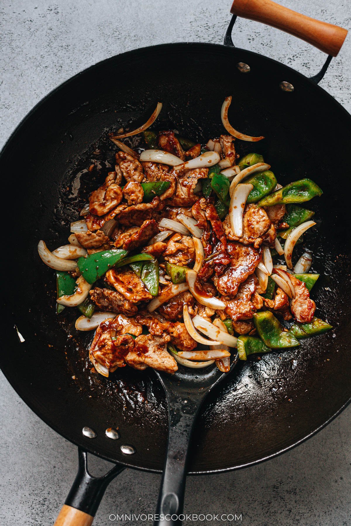 Stir fry pork with bell pepper and onion cooking in a wok