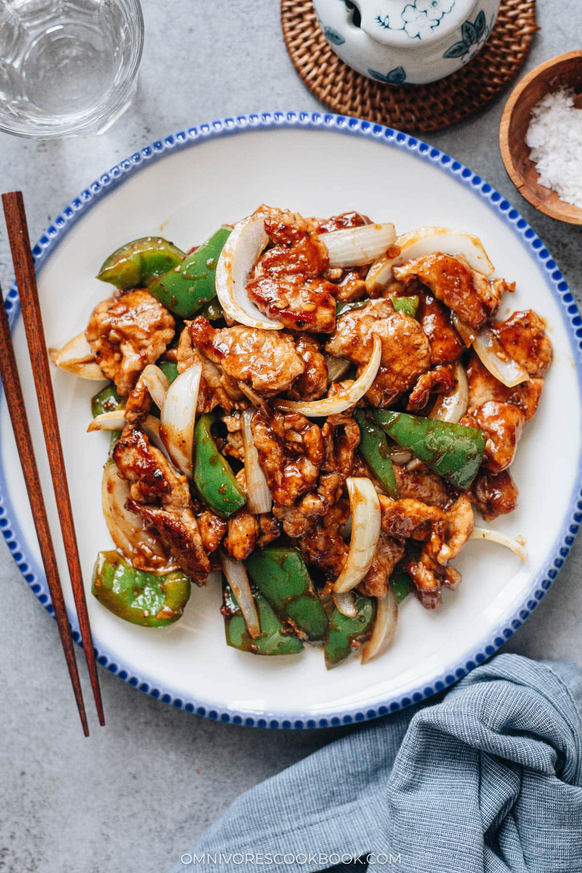 Pork and pepper stir fry plated with chopsticks on the side