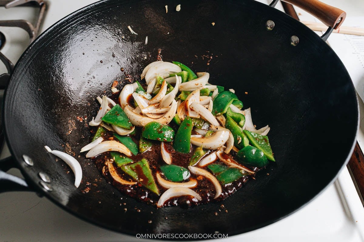Bell pepper and onion stir frying in sauce in the wok