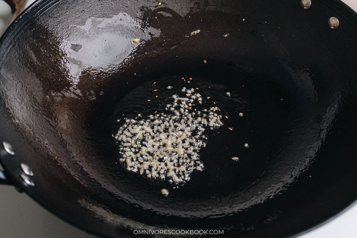 Garlic sizzling in oil in a wok