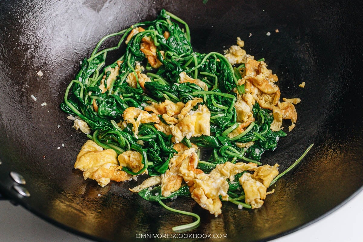 Spinach and eggs tossed in a wok