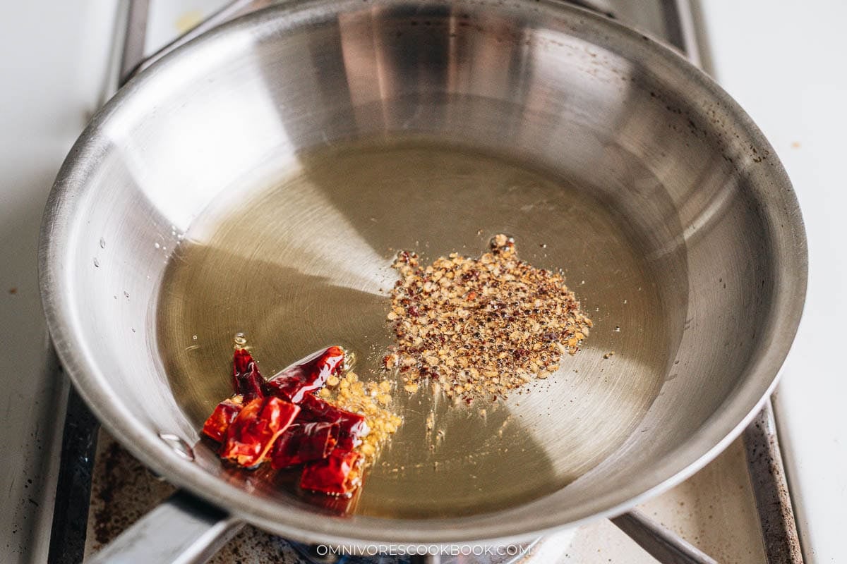 Heating oil with dried chilies and Sichuan peppercorn