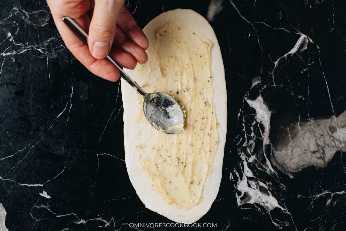 Spread a layer of the butter flour paste over oval dough