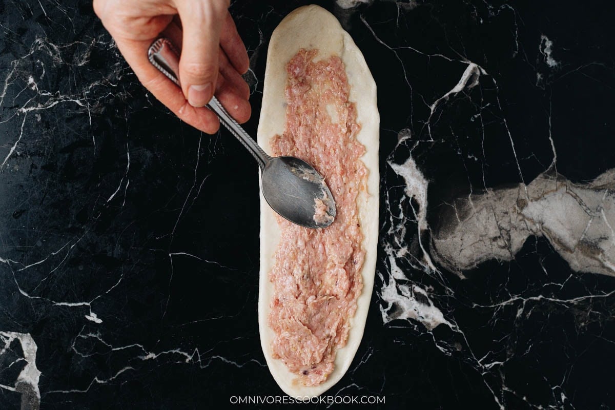 Spread the pork filling evenly over the rolled and stretched dough