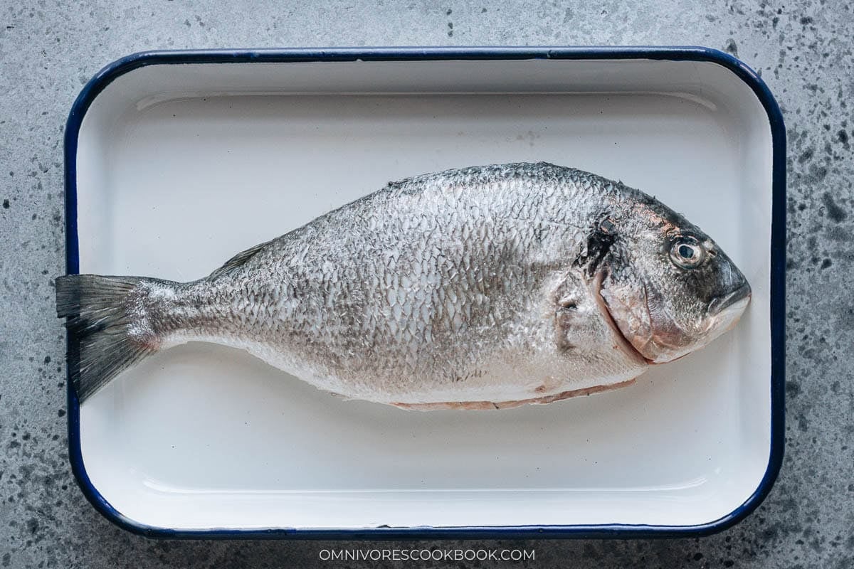 Raw whole royal dorade in a plate