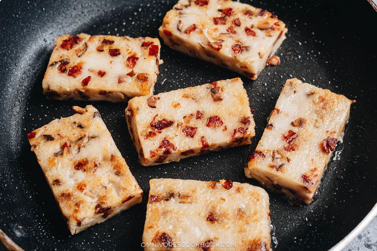 Chinese turnip cake frying on a pan