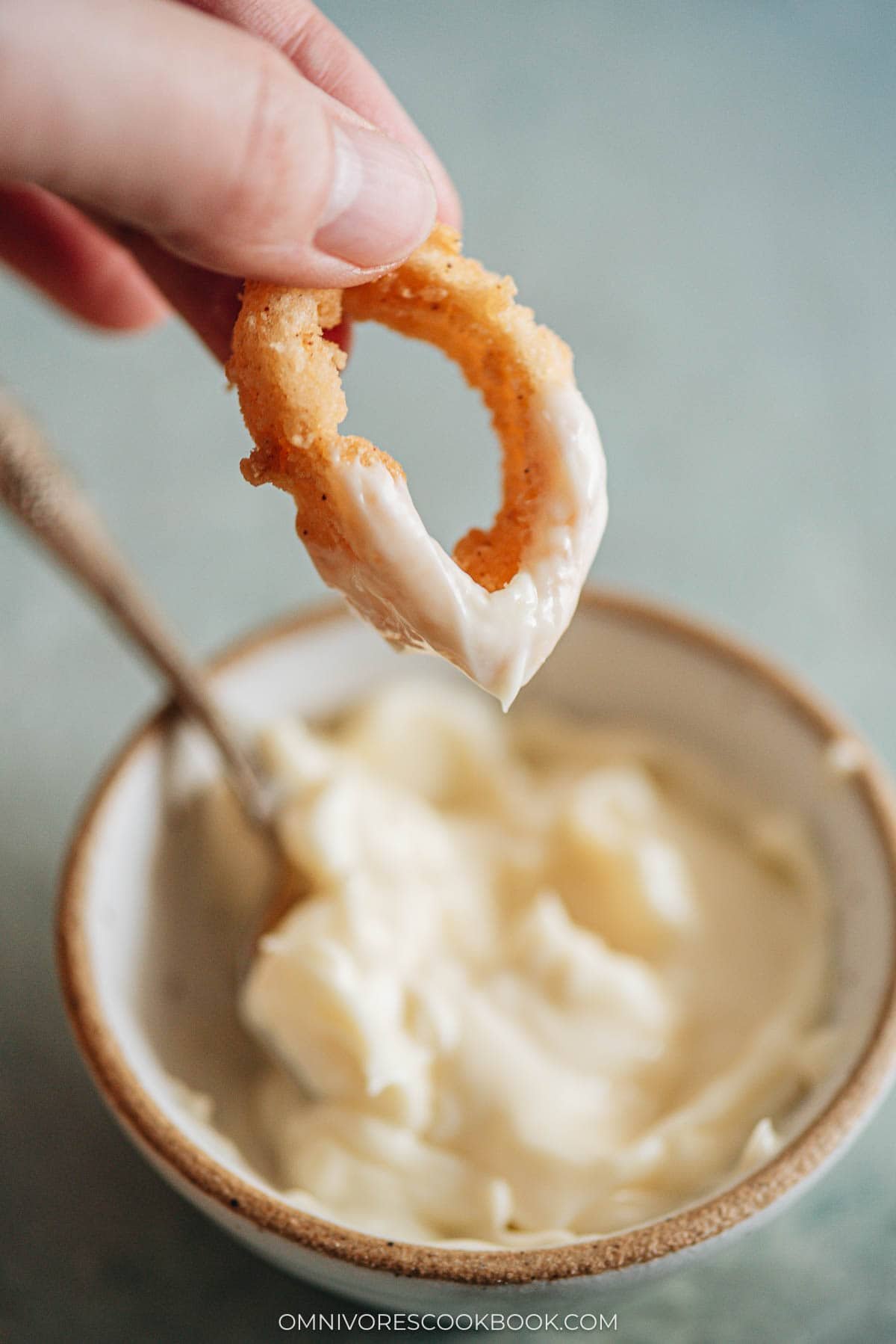 dipping fried squid in a sauce