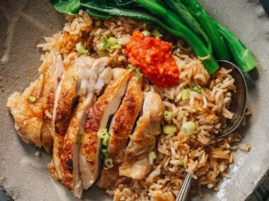 Carved chicken served on rice with Chinese broccoli