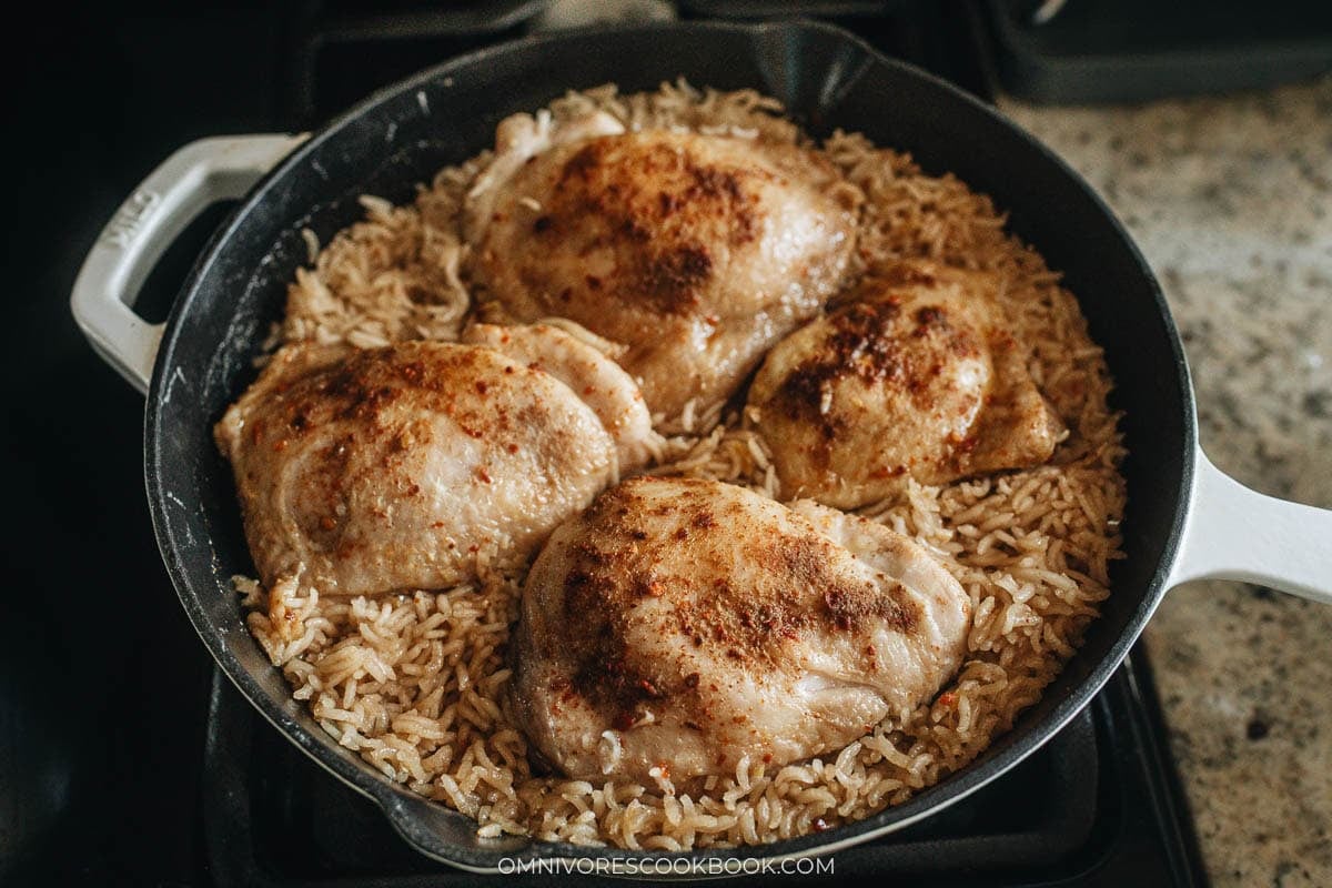 cooking rice and chicken in a skillet