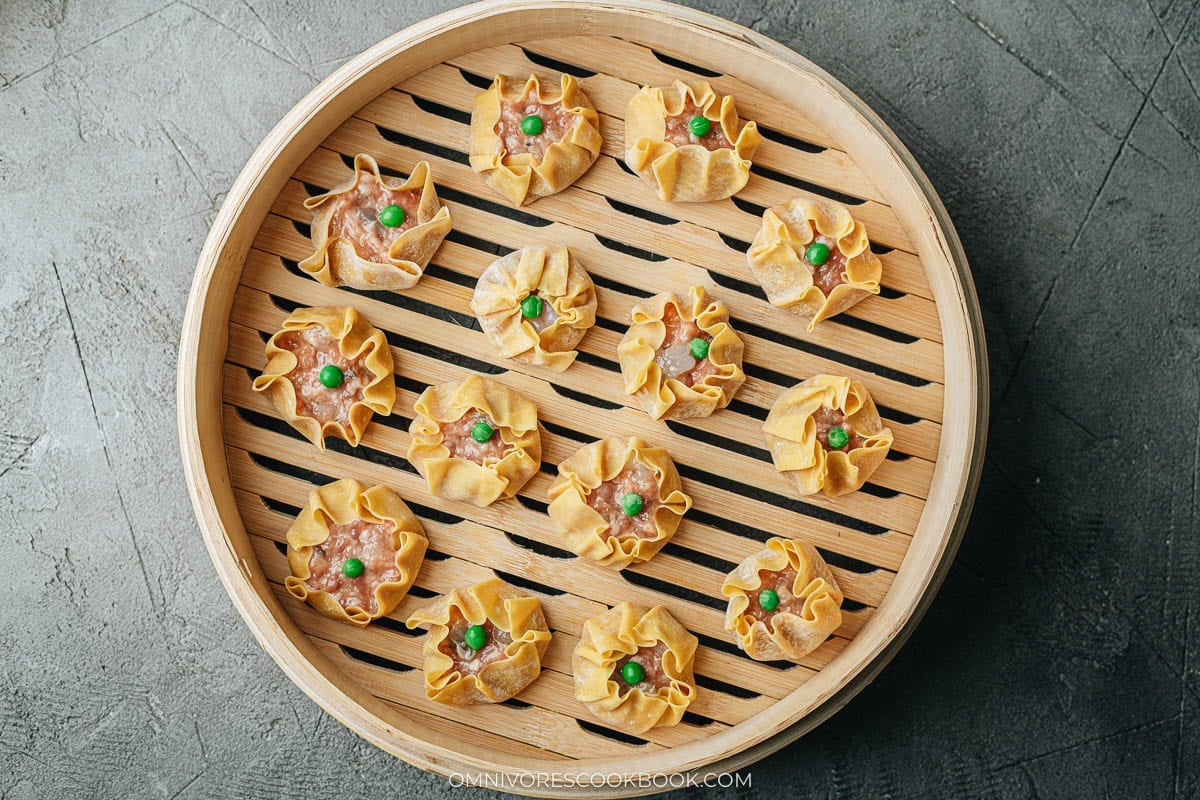 Uncooked shumai in a bamboo steamer