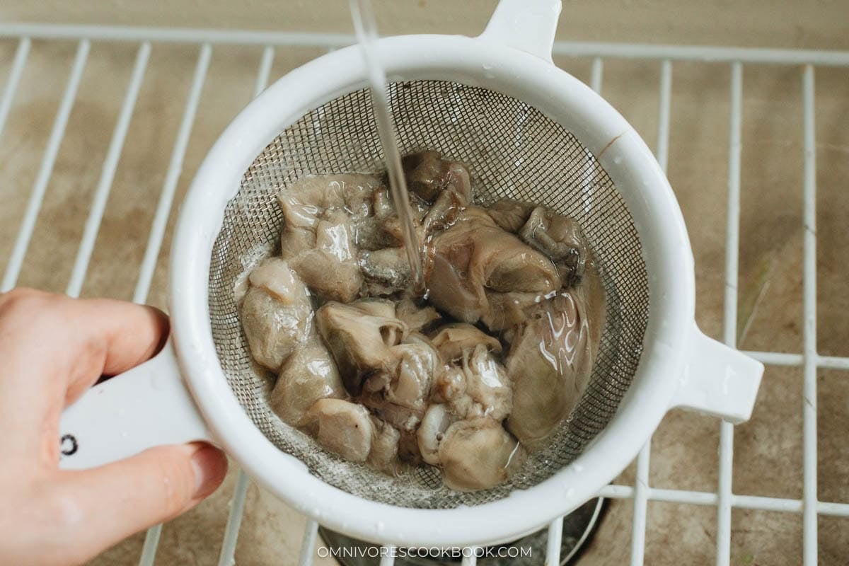 cleaning the oyster with cornstarch rinsing in a colander