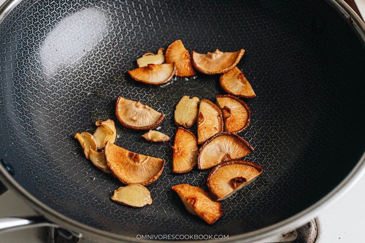 Cook rehydrated shiitake mushrooms and ginger in a wok