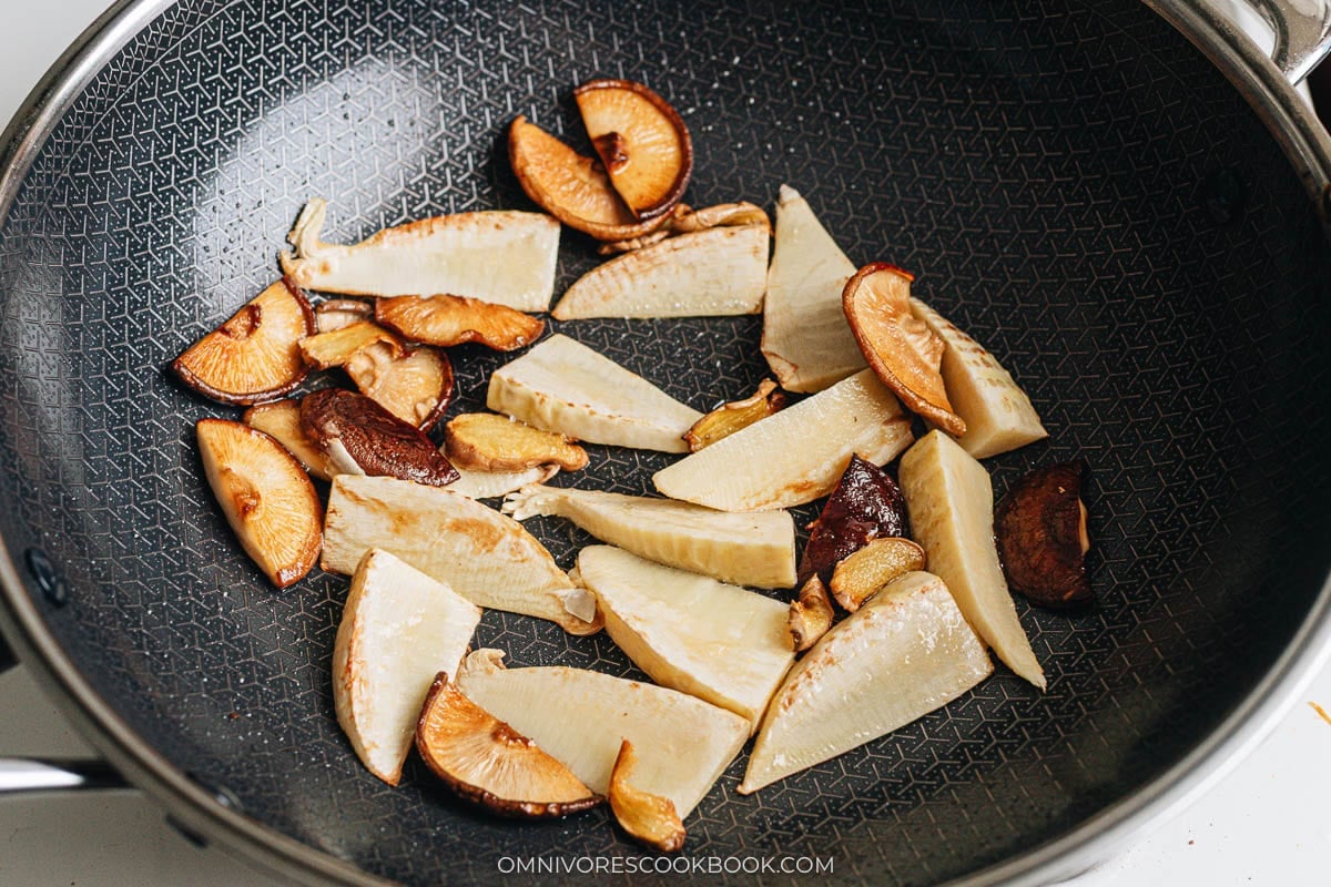 Stir frying bamboo shoots and mushrooms in a wok